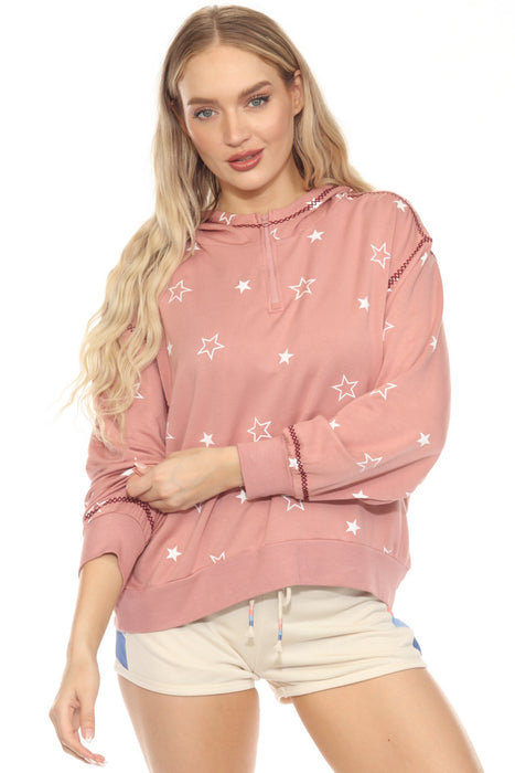 Woman wearing a pink hoodie with star patterns and quarter zip