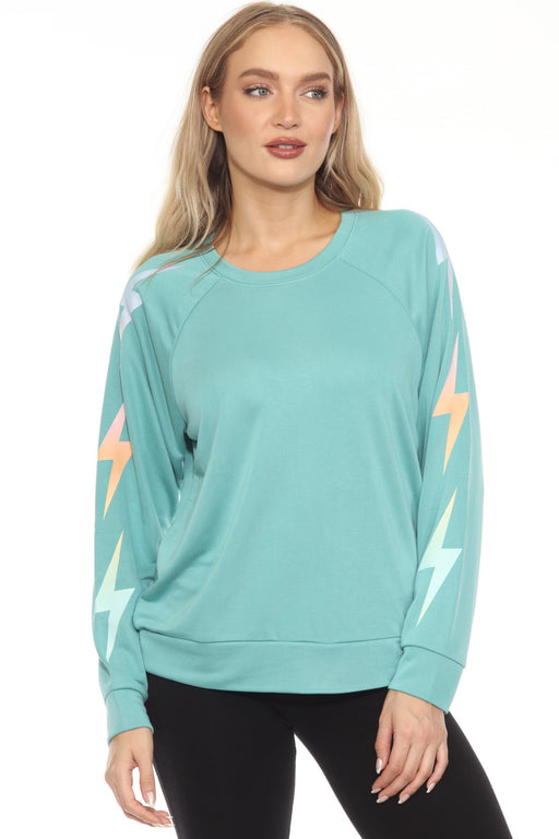 Woman wearing a sea green pullover French terry sweatshirt with gradient lightning bolt graphic on the sleeves