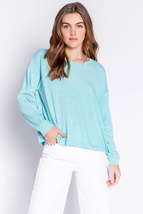 Woman wearing a light blue solid color pullover lounge t-shirt with crew neck and long sleeves