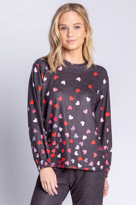 Woman wearing a dark gray lounge pullover top with hearts print all over
