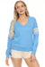 Woman wearing a blue terry pullover lounge top with pastel rainbow stripes on the sleeves