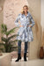 Woman wearing Samuel Dong Blue Loden print bubble coat dress with statement collar, self-tie belt, and bubble hem